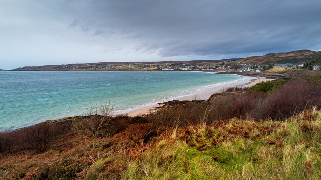 Hohe Winkelansicht der Stadt Gairloch nahe dem Meer im Hochland, Schottland an einem düsteren Tag