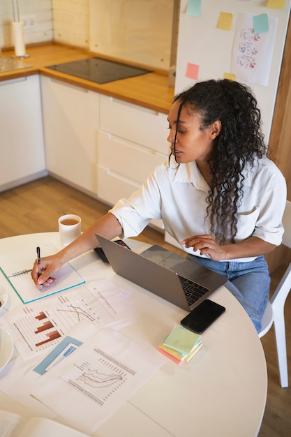 Hohe Winkelfrau, die an Laptop arbeitet