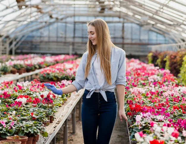 Kostenloses Foto hohe winkelfrau, die blumen betrachtet