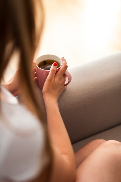 Hohe Winkelfrau, die eine Tasse Tee anhält