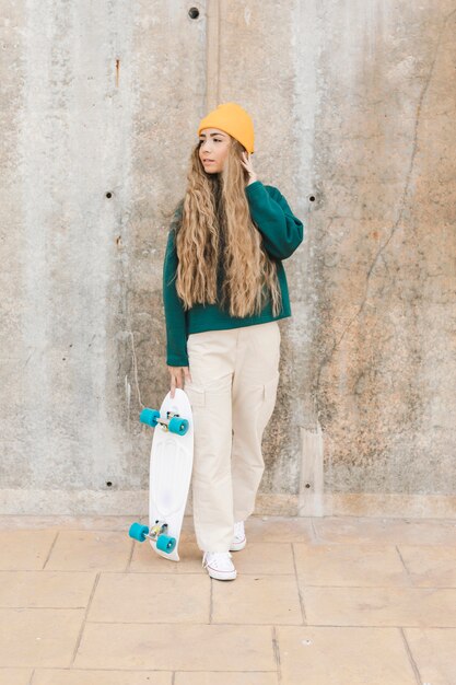Hohe Winkelfrau, die Skateboard hält