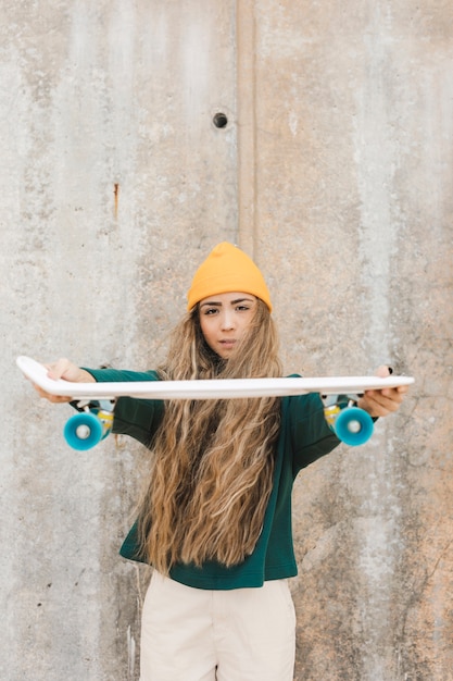 Hohe Winkelfrau, die Skateboard hält