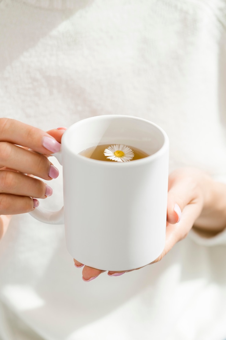 Kostenlose Foto hohe winkelfrau, die weißen becher mit tee hält