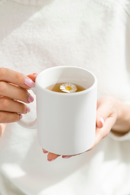 Hohe Winkelfrau, die weißen Becher mit Tee hält