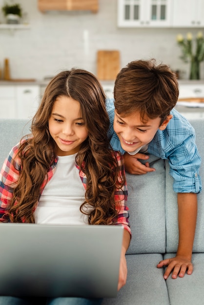 Kostenloses Foto hohe winkelgeschwister, die zusammen laptop verwenden