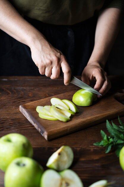 Hohe Winkelhände, die Apfel schneiden