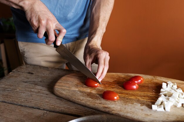Hohe Winkelhände, die Tomaten schneiden