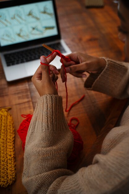 Hohe Winkelhände, die zu Hause stricken