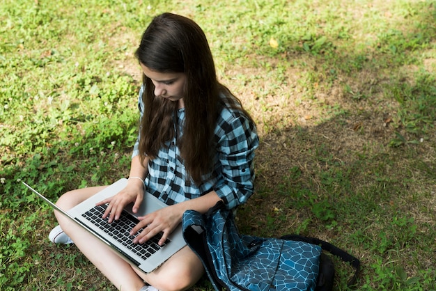 Hohe Winkeljugendliche, die an Laptop arbeitet