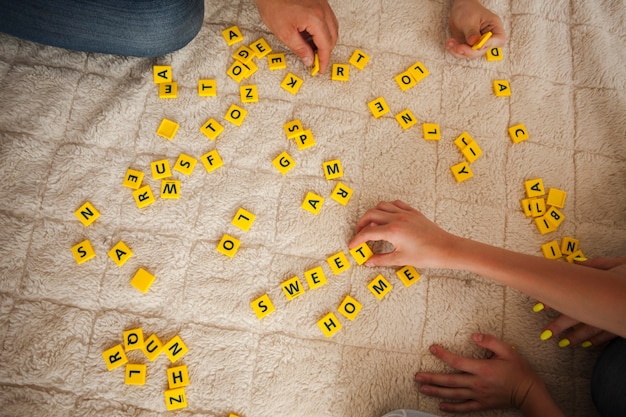 Hohe winkelsicht der hand scrabblespiel auf teppich spielend