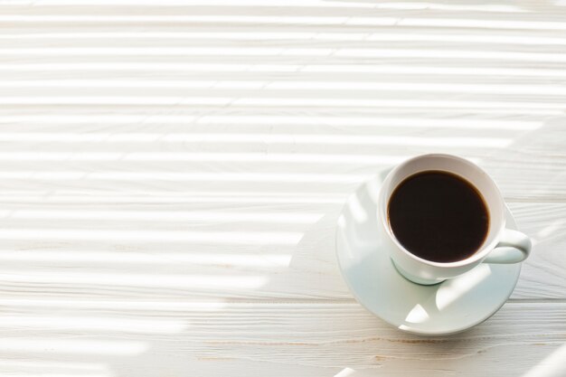 Hohe Winkelsicht der köstlichen Espressokaffeetasse über weißem Holztisch