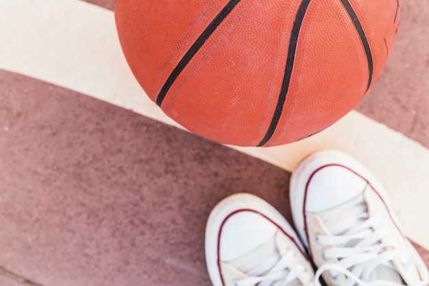 Hohe winkelsicht des basketballs und der turnschuhe