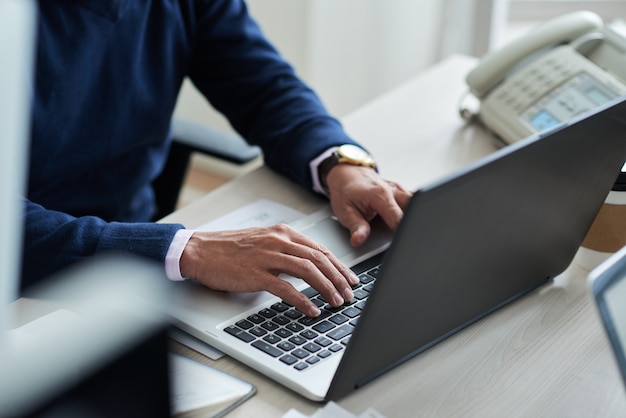 Hohe Winkelsicht des geernteten Angestellten bei der Arbeit mit Laptop