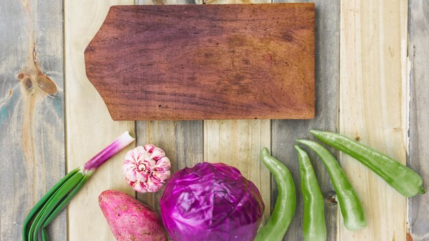 Hohe Winkelsicht des hackenden Brettes mit frischem gesundem Gemüse auf Holzoberfläche