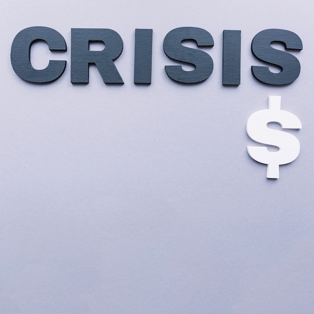 Kostenloses Foto hohe winkelsicht des krisenwortes mit dollarzeichen auf grauem hintergrund