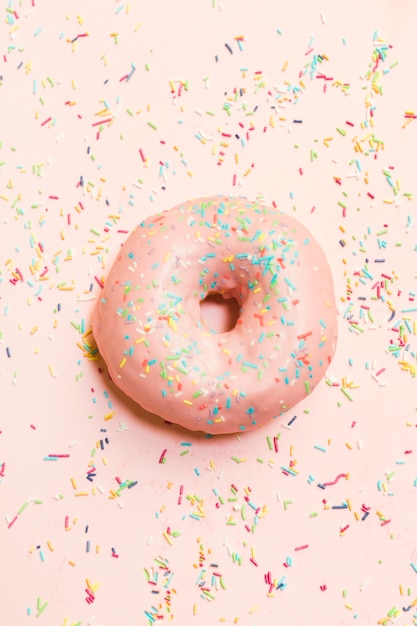 Hohe Winkelsicht des süßen Donuts umgeben durch bunte Sprinkles