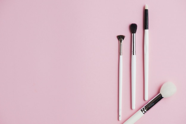 Hohe Winkelsicht von Make-upbürsten auf rosa Hintergrund