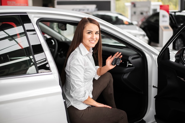 Hohe Winkelsmileyfrau, die im Auto sitzt