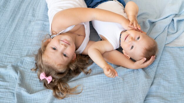 Hohe Winkelsmileykinder, die im Bett sitzen