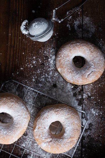 Hoher Krapfenwinkel mit Puderzuckerglasur und Sieb