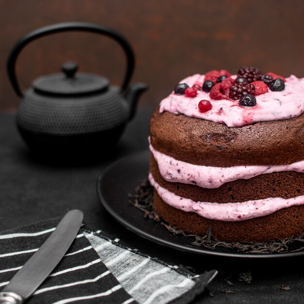 Hoher Kuchenwinkel mit Messer und Teekanne