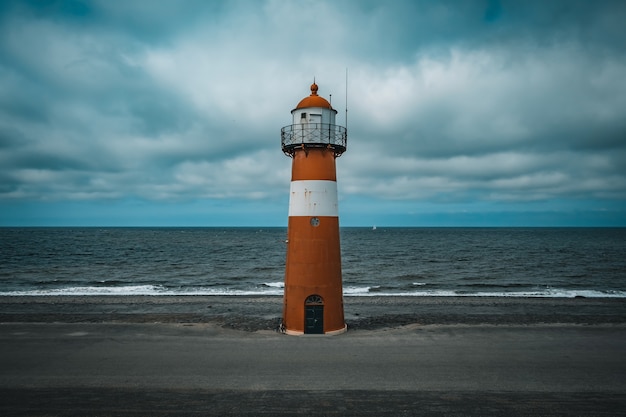 Kostenloses Foto hoher leuchtturm an der nordsee bei bewölktem himmel