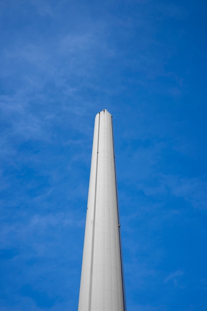 Hoher Schornstein des niedrigen Winkels mit blauem Himmel