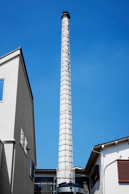 Hoher Schornstein mit niedrigem Winkel in der Nähe von Gebäuden