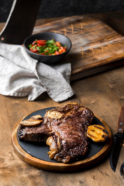 Hoher Steakwinkel auf Teller mit Besteck