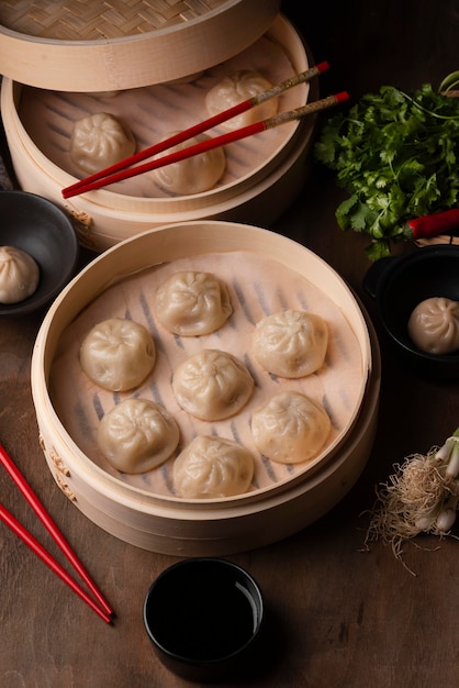 Hoher Winkel der asiatischen Knödel mit Stäbchen und Kräutern