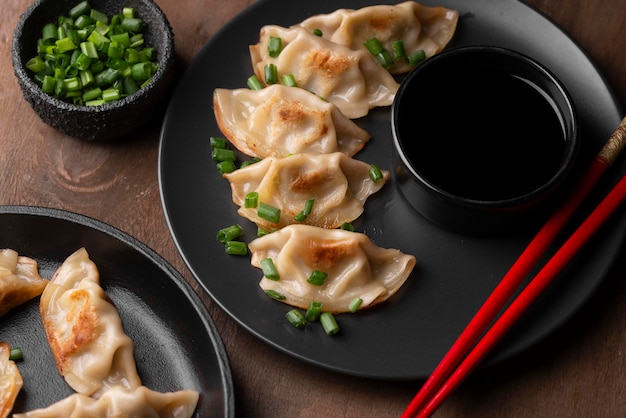 Kostenloses Foto hoher winkel der asiatischen knödelschale mit stäbchen und kräutern