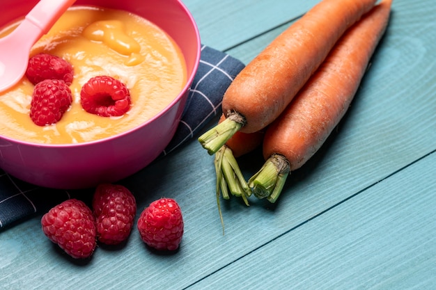 Hoher Winkel der Babynahrung mit Himbeeren und Karotten