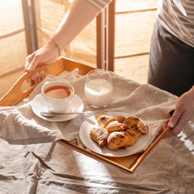 Hoher Winkel der Desserts auf Tablett mit Milch und Tee