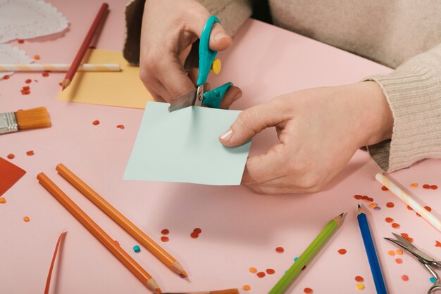 Hoher Winkel der Frau blaues Papier schneiden