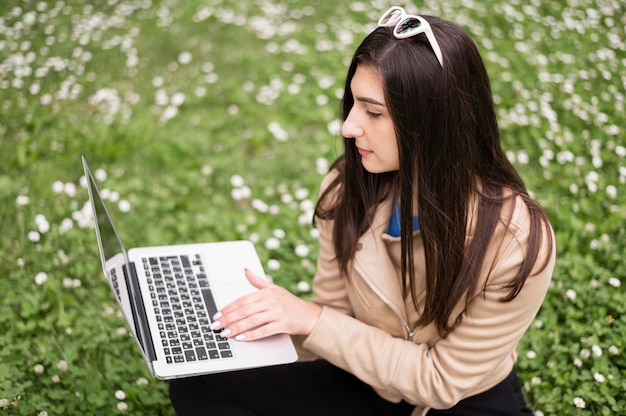 Hoher Winkel der Frau, die an Laptop im Freien arbeitet