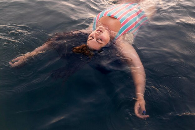 Hoher Winkel der Frau, die im Wasser am Strand entspannt