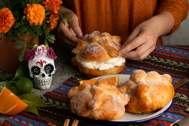 Kostenloses Foto hoher winkel der frau, die pan de muerto . macht