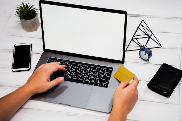 Hoher Winkel der Hand auf Laptopschlüsselwort auf Holztisch