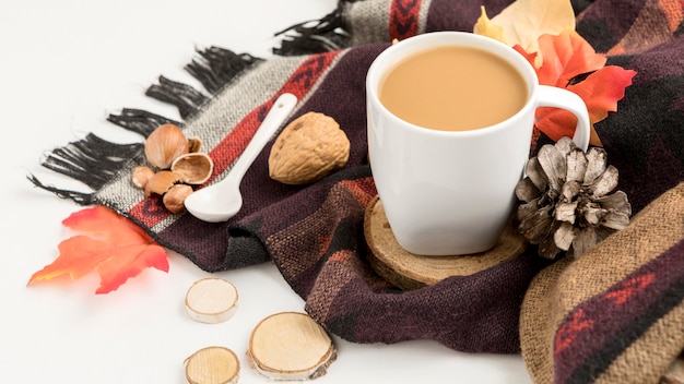 Hoher winkel der kaffeetasse mit tannenzapfen und herbstlaub