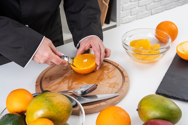 Hoher Winkel der Köchin, die eine Orange schneidet