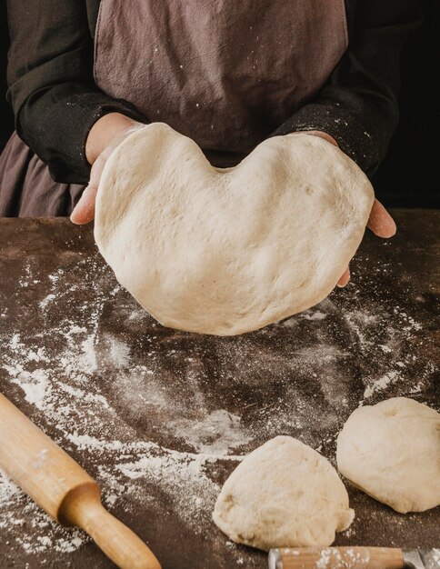 Hoher Winkel der Köchin, die gerollten Pizzateig zeigt