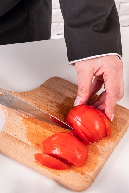 Hoher Winkel der Köchin, die Tomaten hackt
