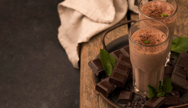 Hoher Winkel der Milchshake-Gläser auf Tablett mit Minze und Kopierraum