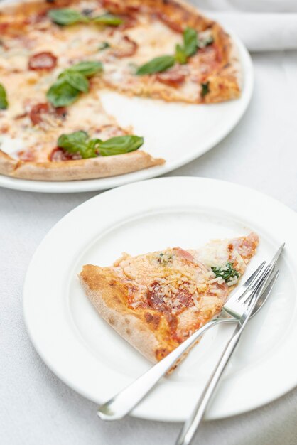 Hoher Winkel der Pizzascheibe auf einer Platte auf normalem Hintergrund