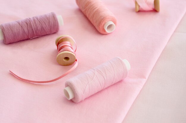 Hoher Winkel der rosa Fadenrollen mit Textil