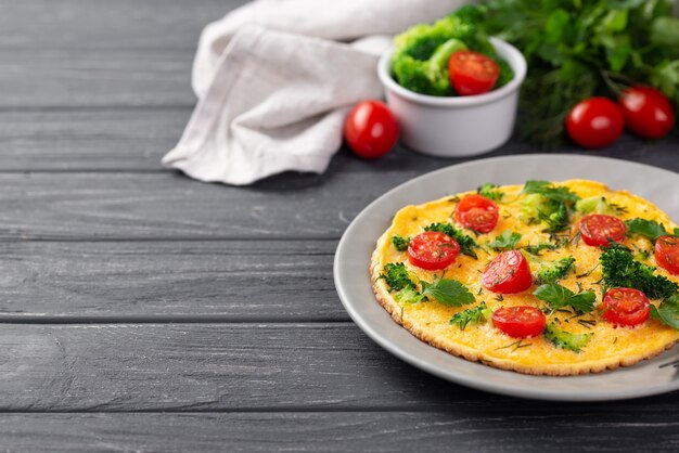 Hoher Winkel des Frühstücksomeletts auf Platte mit Tomaten und Brokkoli