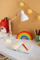Kostenloses Foto hoher winkel des kinderschreibtisches mit regenbogen und notizbuch