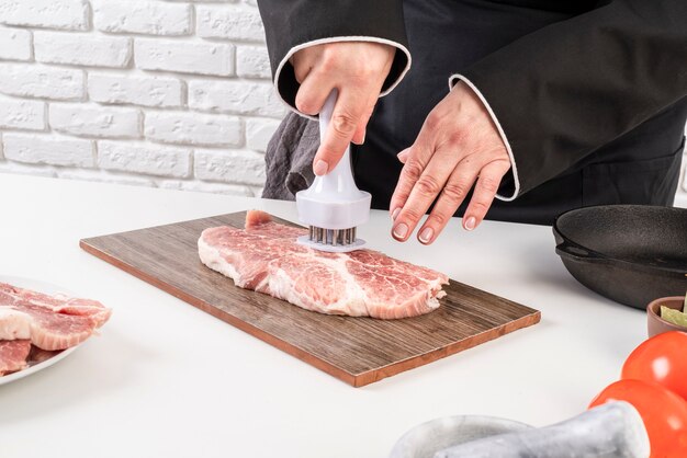 Hoher Winkel des Küchenchefs, der Fleisch zart macht