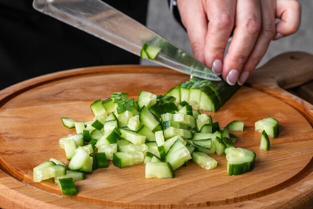 Hoher Winkel des Küchenchefs, der Gurken hackt