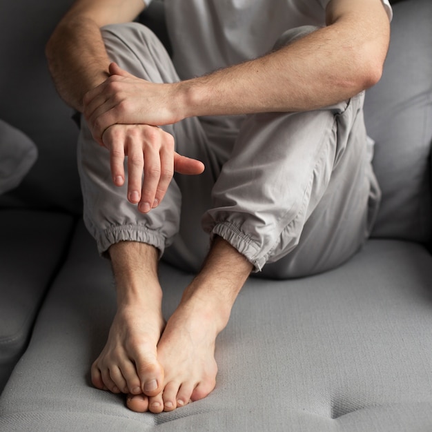 Hoher Winkel des Mannes aufwerfend beim auf der Couch sich hinsitzen